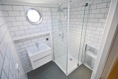 a bathroom with a sink, toilet and shower stall in it's corner area