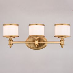 three light brass bathroom fixture with white shades