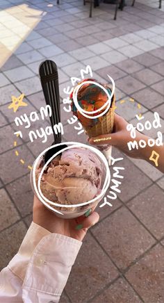 two people holding up ice creams in front of a building with writing on it