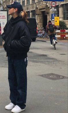 a woman standing in the middle of an empty street