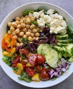 a salad with chickpeas, tomatoes, cucumbers and lettuce