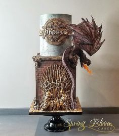 there is a cake made to look like a game of thrones tower with a dragon on top