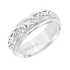 a wedding band with an intricate design on the side and engraving in white gold,