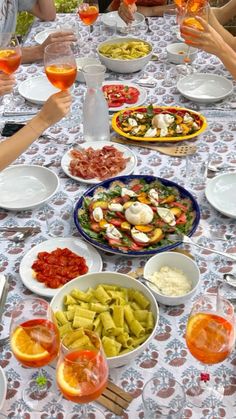 a group of people sitting around a table filled with food