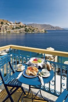 there is a table with food on it next to the ocean