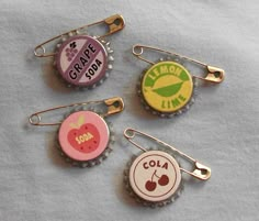 four bottle caps with the words grape soda, lemon lime, and cola on them