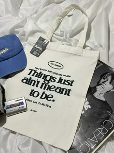 a white bag with an advertisement on it next to a blue hat and other items