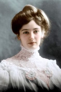 an old photo of a woman in a white dress with her hair pulled back and wearing a lace collar