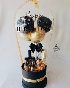 a birthday gift basket with chocolates, cookies and candies in a glass dome