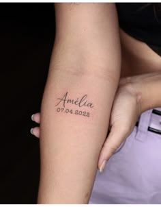 a woman's arm with the name and date tattooed on it