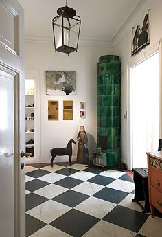 a black and white checkered floor in a room with a light fixture hanging from the ceiling