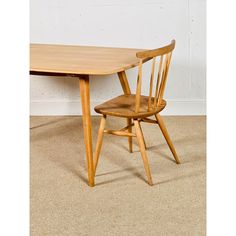 a wooden table with two chairs sitting next to each other on carpeted flooring