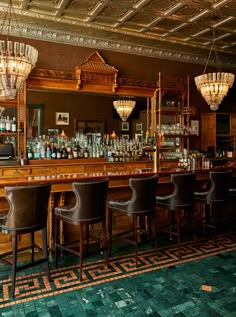 a bar with several chairs and lights hanging from the ceiling