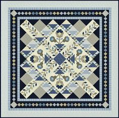 a blue and white quilt with an intricate design on the front, featuring leaves and flowers