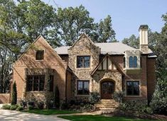 a brick and stone house with trees in the background