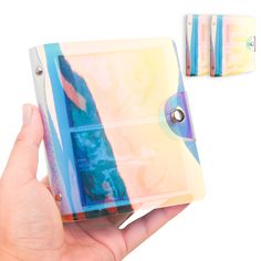 a hand holding an empty cd case in front of two other cds on a white background