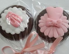 two cupcakes wrapped in cellophane and decorated with pink bows, bow and ribbon