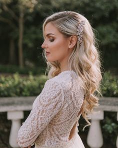 a woman with long hair wearing a white dress and holding her hand on her hip