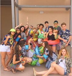 a group of young people posing for a photo in front of a building with an inflatable pool