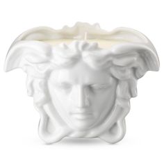 a white candle holder with a face on the front and back of it's head