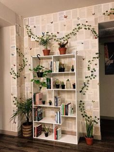 a book shelf filled with lots of books next to a wall covered in plant life