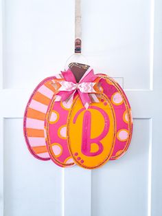 an orange and pink pumpkin shaped door hanger with the letter b on it's side