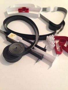 several different types of scissors and tape on a white surface with some red, black, and grey handles