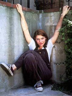 a woman sitting on the ground with her arms up