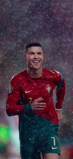 a soccer player is running in the rain