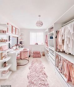 a white closet filled with lots of pink and white items, including clothes hanging on shelves