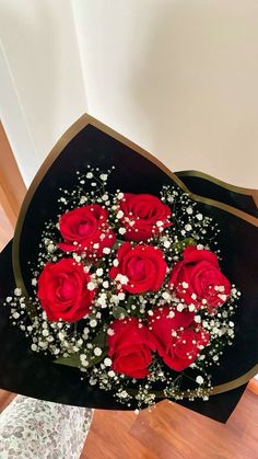 a woman holding a bouquet of red roses