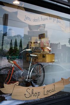 a bicycle is parked in front of a store window with a sign that says, you don't have to go far