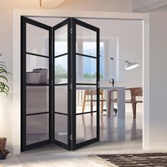 an open room door in front of a table and chair with a potted plant