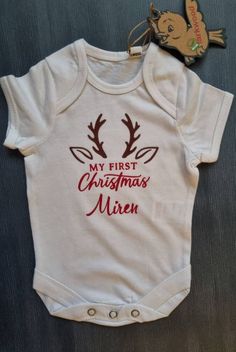 Christmas Reindeer Organic Baby Bodysuit. This adorable bodysuit is an ideal way to mark your little ones first Christmas or to give as a gift.  Order Can be personalised with childs name for that extra special gift.  Bodysuit is made from 100% organic cotton, single jersey, envelope neckline, bottom popper closure.  Design is made with heat transfer vinyl. Sizes: Newborn, height 56 cm  0-3 Months, height 62 cm 3-6 Months, height 62-68 cm 6-12 Months, height 68-80 cm NOTE: Longer names or double barrelled names may need to be done in a smaller size to fit or may need to be on two rows.  If unsure please contact me. All items are handmade and may not be identical. **All free postage items are sent by Royal Mail 2nd class post, delivery estimated 3 working days. Option to upgrade to Express Backpack Gift, Machine Embroidery Projects, Writing Gifts, Boys Backpacks, Toddler Christmas, Personalised Baby, Girl Backpacks, Organic Baby, Personalised Kids