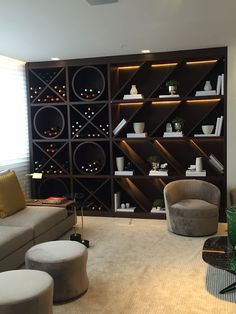 a living room filled with lots of furniture next to a wall covered in wine bottles