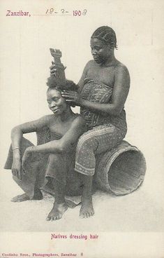 an old black and white photo of two women combing each other's hair