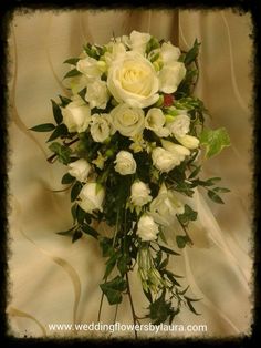 a bridal bouquet with white roses and greenery on a silk background for a wedding