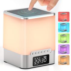 a person pressing the button on a colorful light up alarm clock with four different color options