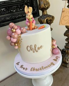 a white cake decorated with pink and gold decorations