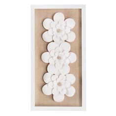 white paper flowers in a shadow box with buttons on the bottom and bottom part of the frame