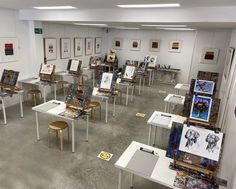 a room filled with lots of paintings and tables