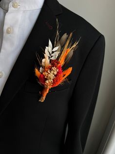 a man in a black suit with feathers on his lapel