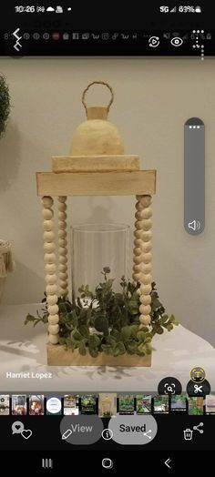 a wooden lantern with plants in it on a table