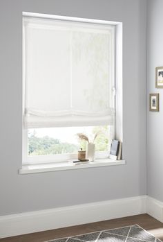 a white window in a room with a rug on the floor and pictures on the wall