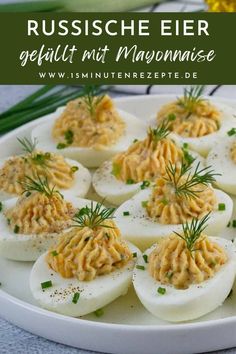 deviled eggs topped with mayonnaise on a white plate