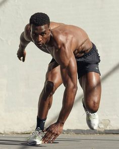 a man with no shirt is playing frisbee