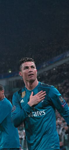 two soccer players are standing in the rain