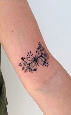 a woman's arm with a butterfly tattoo on the left side of her arm