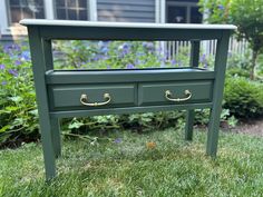 a green table with two drawers in the grass