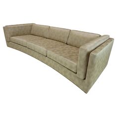 a beige leather couch sitting on top of a white floor